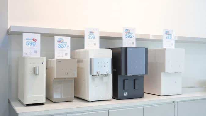 Several water dispensers on a shelf
Description automatically generated